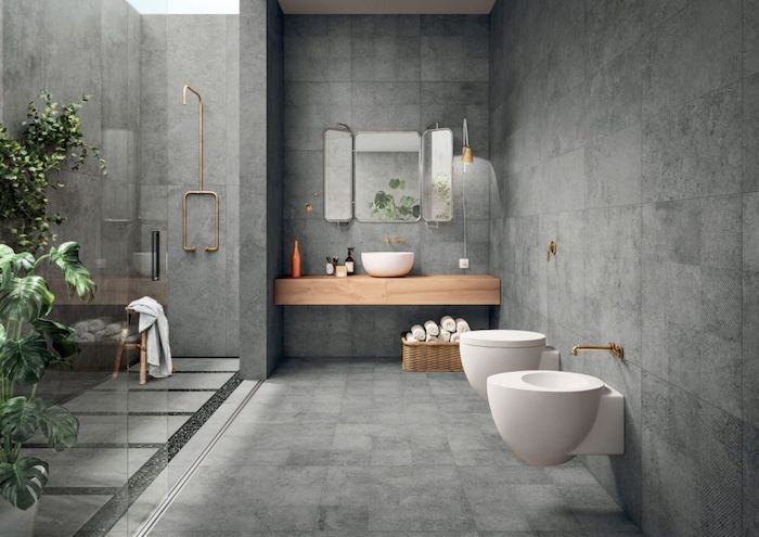 salle de bain pierre naturelle et bois murs et plancher en gris foncé accents en laiton plantes dans la salle de bain