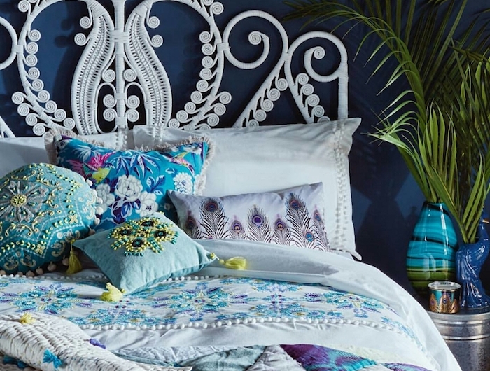 tete de lit blanche en macramé deco de coussins bleus et blancs vases bleus couverture en bleu gris violet
