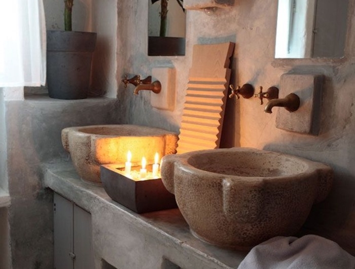 vasque en pierre meuble sous évier en pierre murs et plancher en travertin bougie et plante