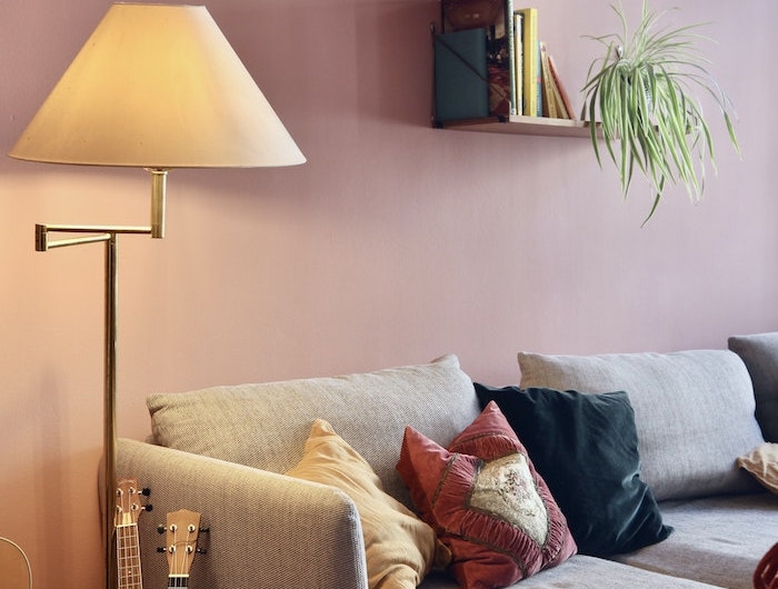 aménagement salon avec canapé gris mur rose tapis coloré et lampe laiton abat jour pour tamiser