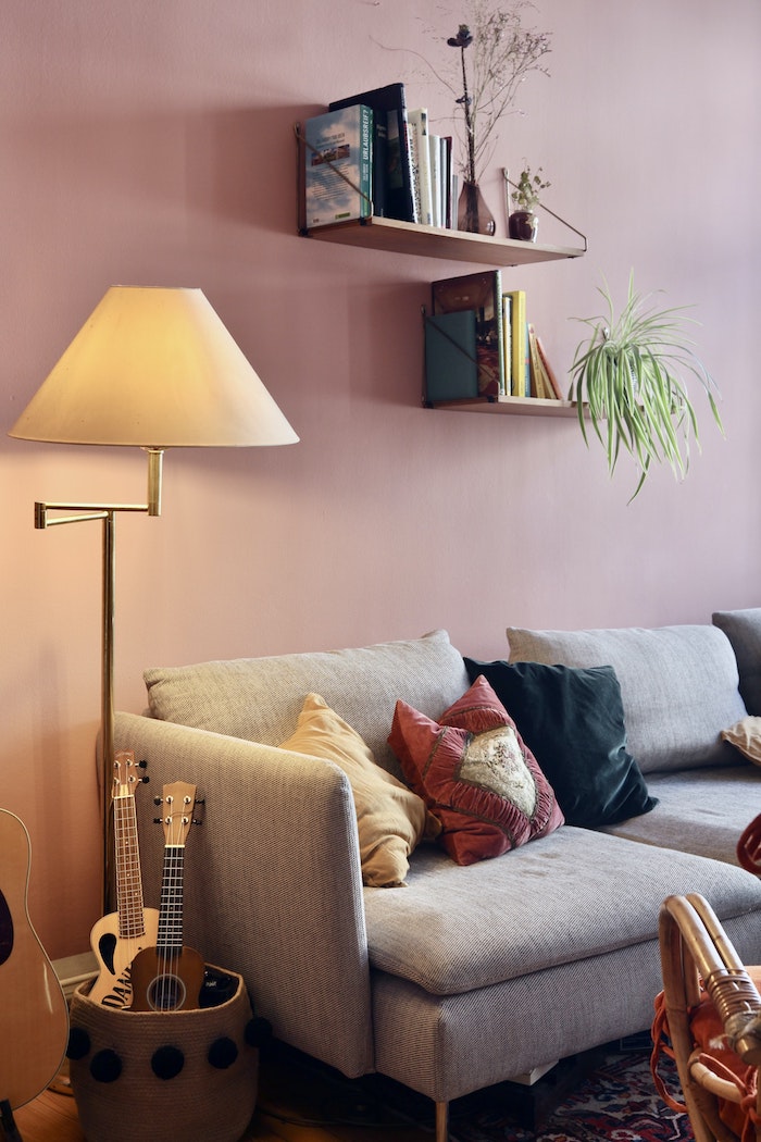 aménagement salon avec canapé gris mur rose tapis coloré et lampe laiton abat jour pour tamiser