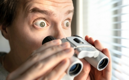 surprised man with binoculars. curious guy with big eyes. nosy n