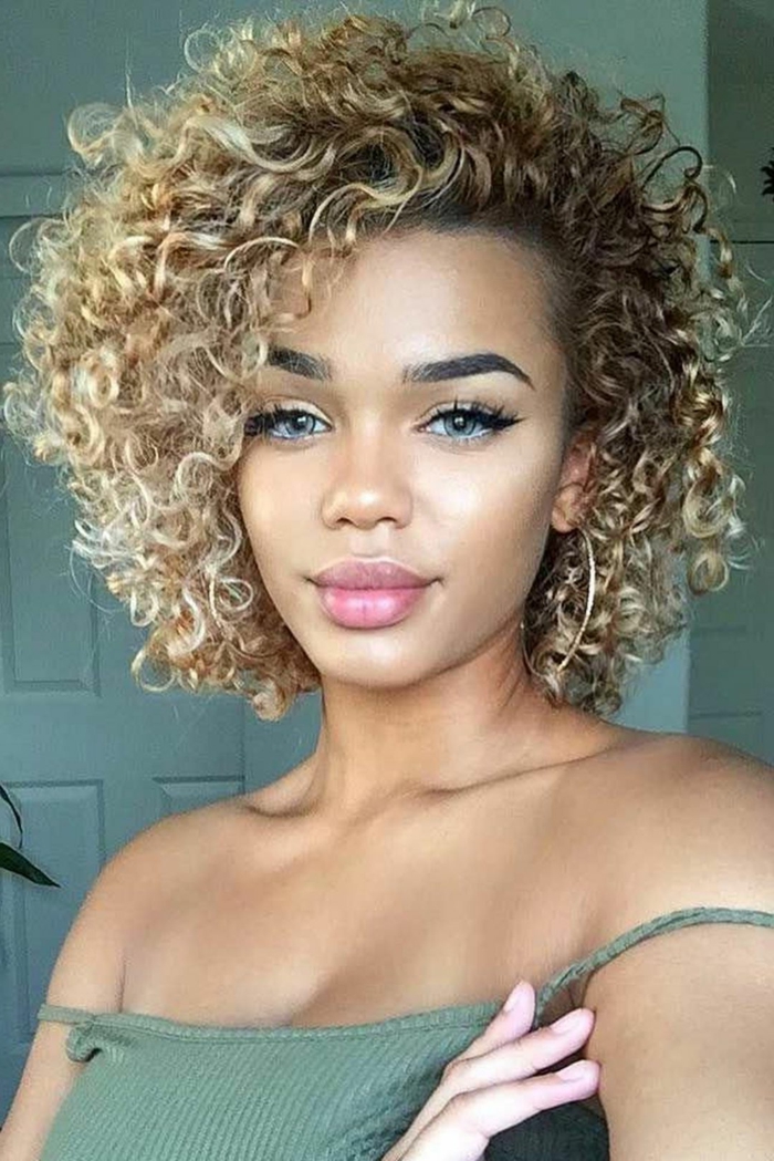 Square curly blonde-haired woman who did a short variable volume hairstyle