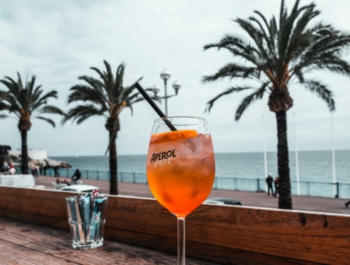 cocktail spritz préparation maison facile boisson plage été palmier terrasse bois