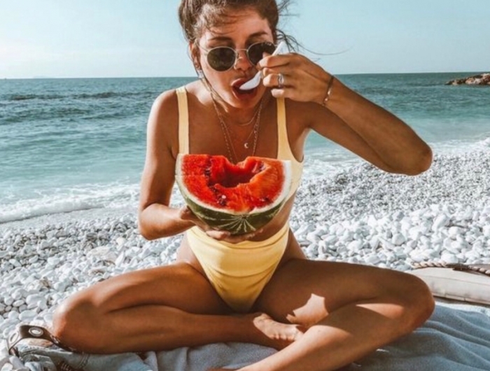 comment bronzer vite une fille qui mange une pastèque à la plage