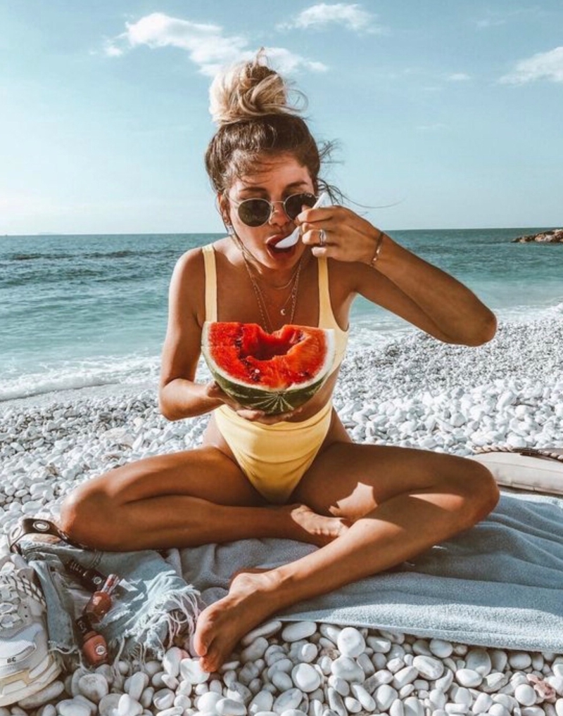 comment bronzer vite une fille qui mange une pastèque à la plage