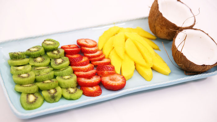 manger une mangue en salade de fruits composée de kiwi fraises noix de coco et mangue