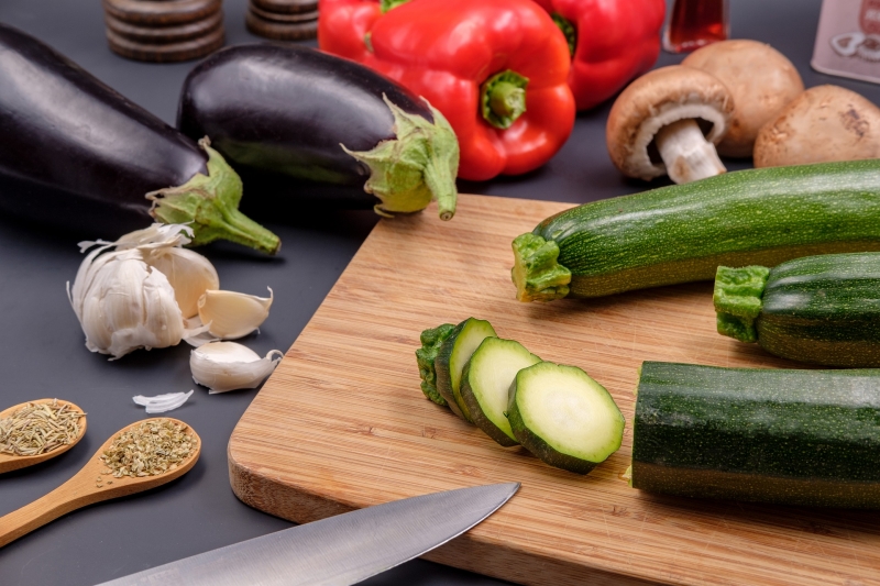 nourriture légumes couper les courgettes couteau cuillère bois épices gousse d ail