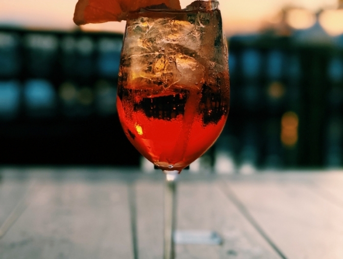 recette spritz verre aperol spritz tranche de citron coucher de soleil été table bois