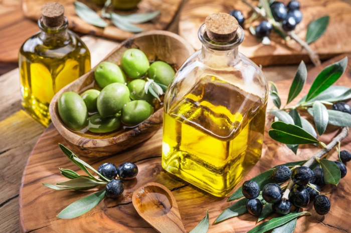 régime méditerranéen huile d'olive dans une bouteille à côté d'une branchette d'olive
