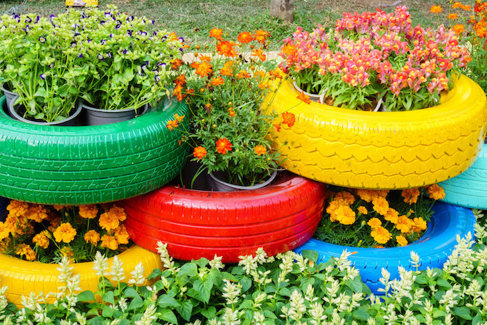 separation de jardin avec des roues recyclés transformées en jardinières