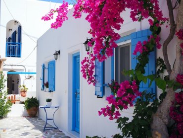 voyage en grèce maison blanche avec fenetres bleues et plantes fuchsia