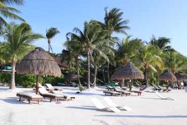 voyager au mexique idée de plage avec chaise longues et parasol de paille palmiers