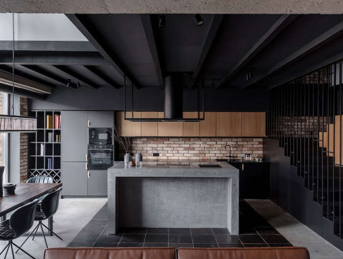cuisine noir et bois avec ilot central en gris plafond et escalier en noir