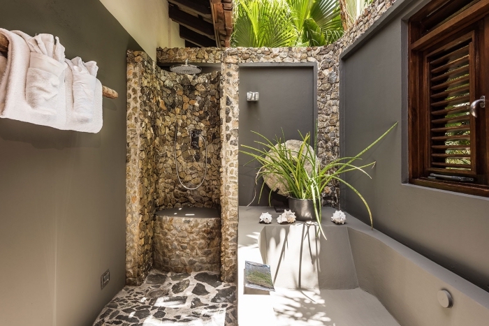 design extérieur aménagement salle de bain exterieur en pierre sur mur façade maison alimentation eau chaude douche jardin
