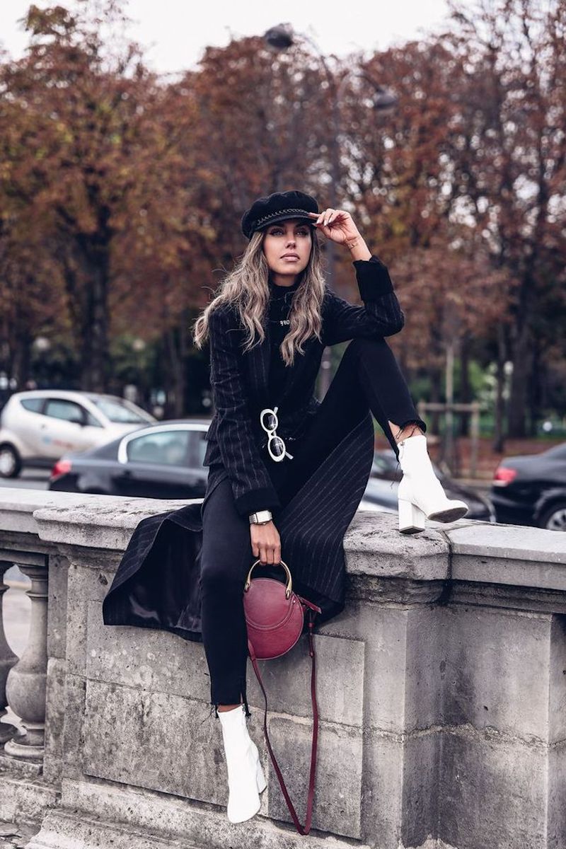 look chic femme en tenue noire avec bottines blanches sac à main en bordeaux