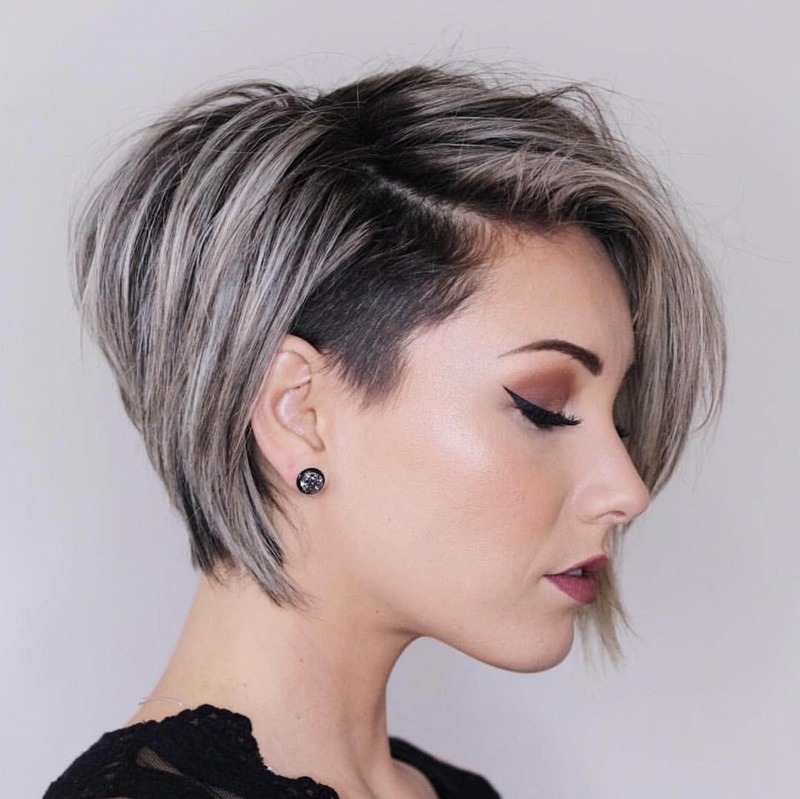 Highlights on ashy blond with black roots coloring short tapered haircut