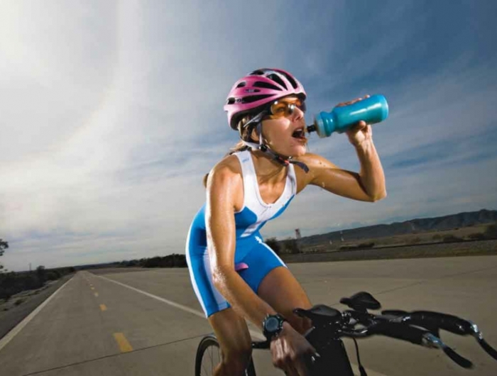 meilleures boissons isotoniques une cycliste qui boit une boisson isotonique
