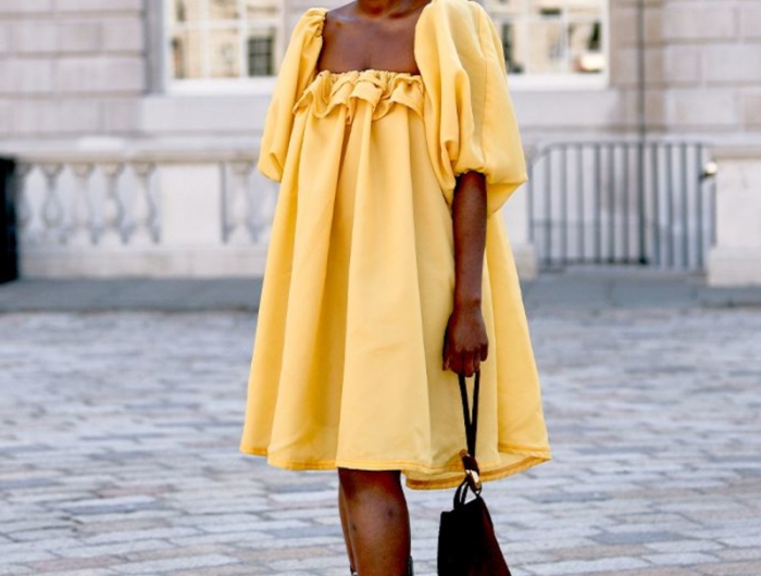 tendance tenue femme en robe fluide jaune bottines en noir et blanc sac à main noir