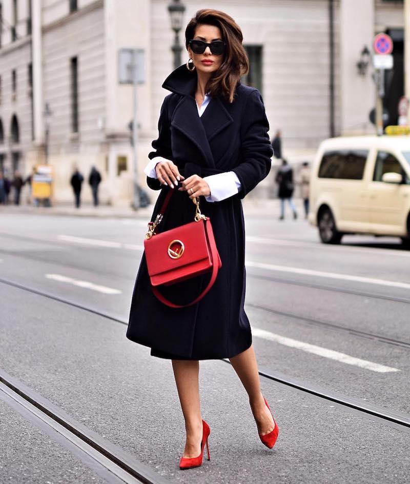 tenue stylée femme en manteau chic en noir avec accessoires en rouge