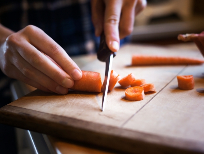 blanchir carotte un couteau qui coupe une carotte sur une planche de bois