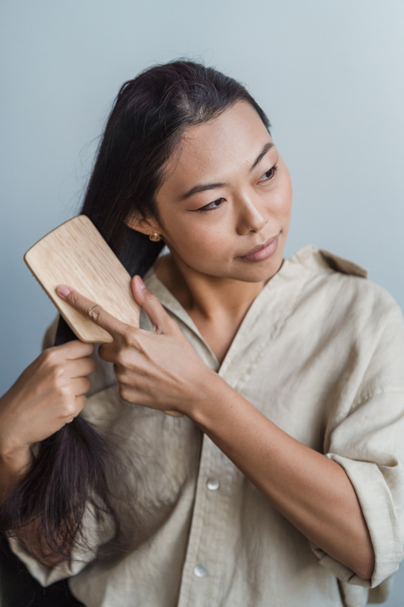 comment nettoyer une brosse à cheveux une femme qui peigne ses cheveux