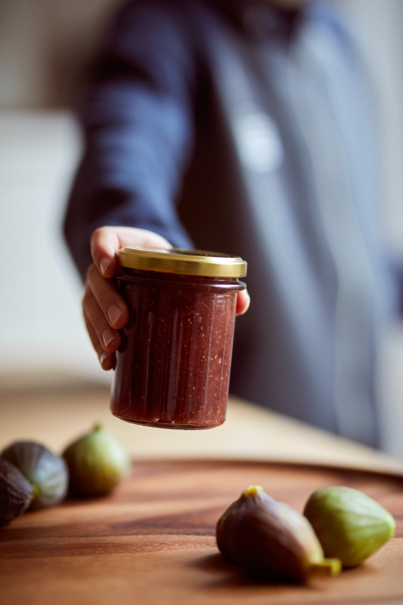 conservation figues une main qui tient un bocal de confiture de figue