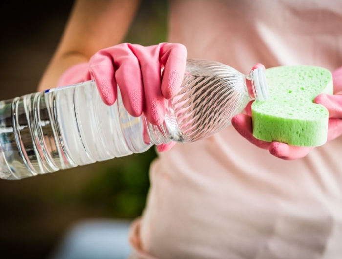 woman using white vinegar to clean