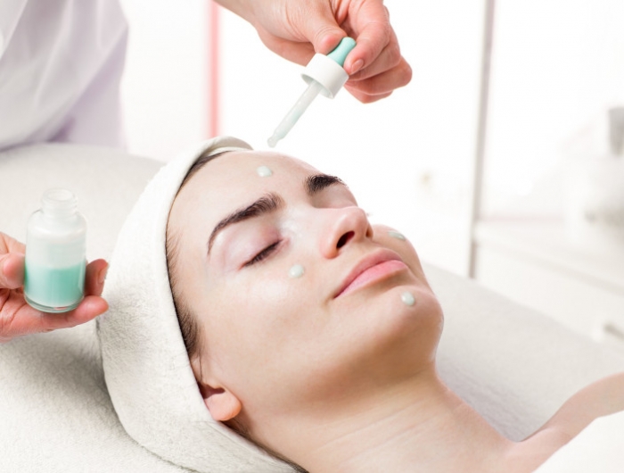 serum facial treatment of young woman in spa salon