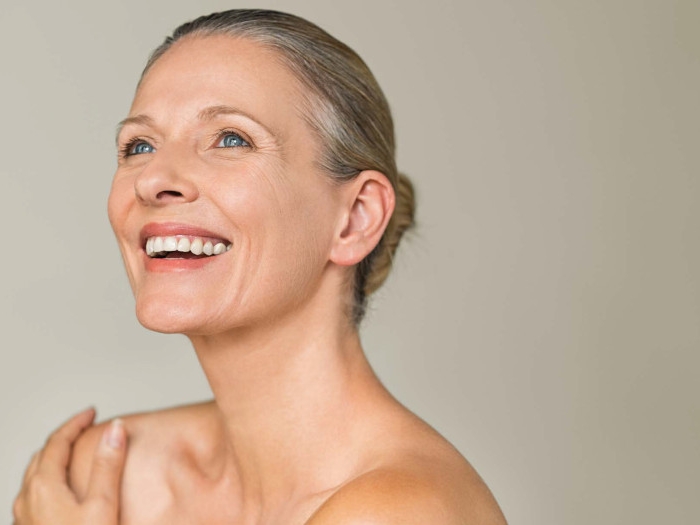 anti vieillissement femme a la peau éclatante à 50 ans qui sourit