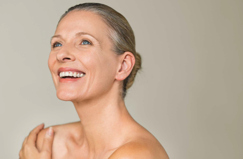 anti vieillissement femme a la peau éclatante à 50 ans qui sourit