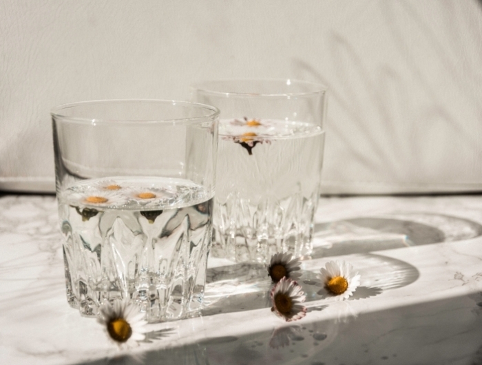 importance boire de l eau verre pétales fleurs surface marbre