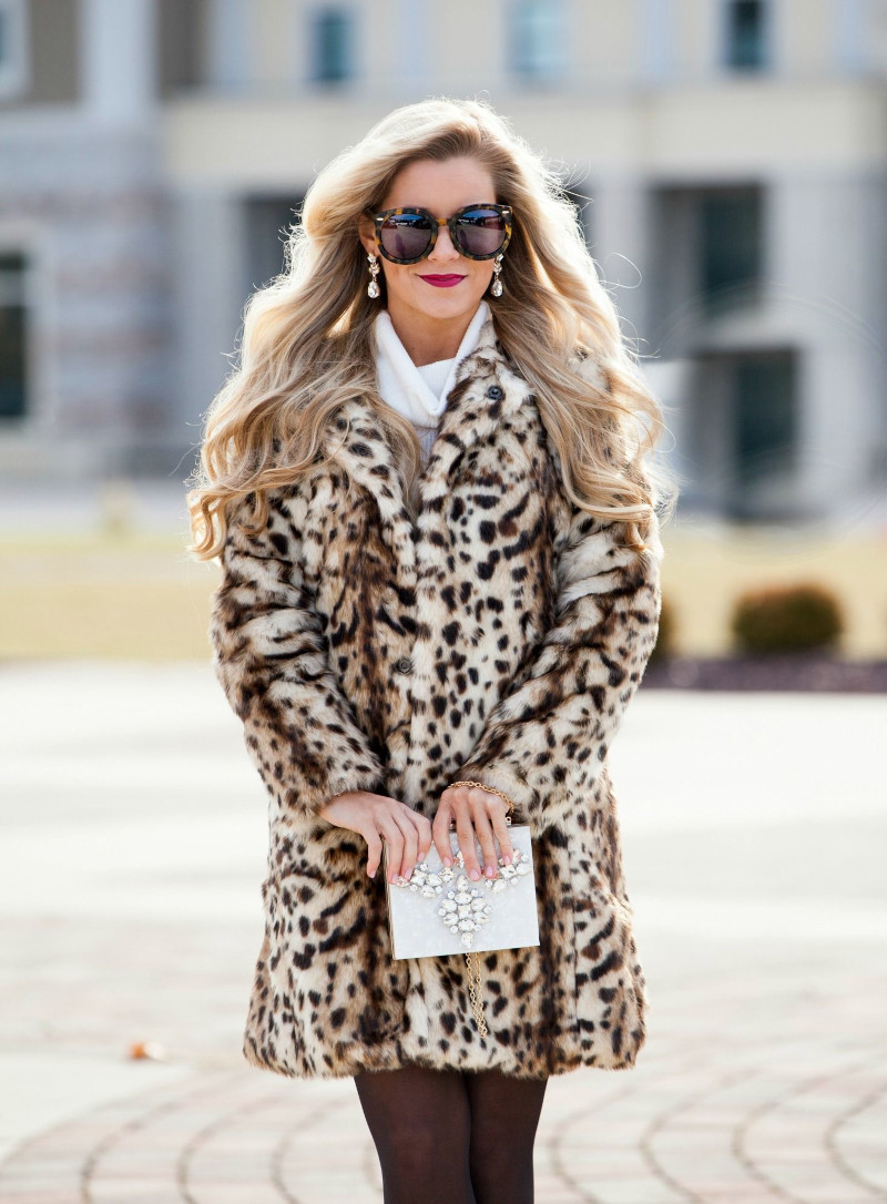 manteau léopard associé à une robe en tricot blanche une pochette blanche