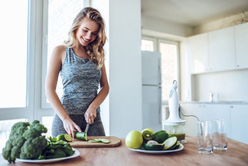 sporty,young,woman,is,preparing,healthy,food,on,light,kitchen.