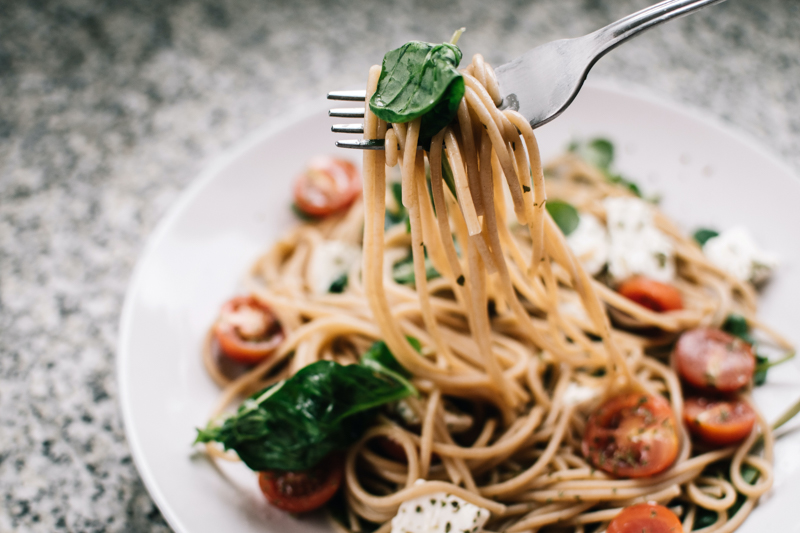 spaghetti alle erbe perenni in un piatto guarniti con basilico