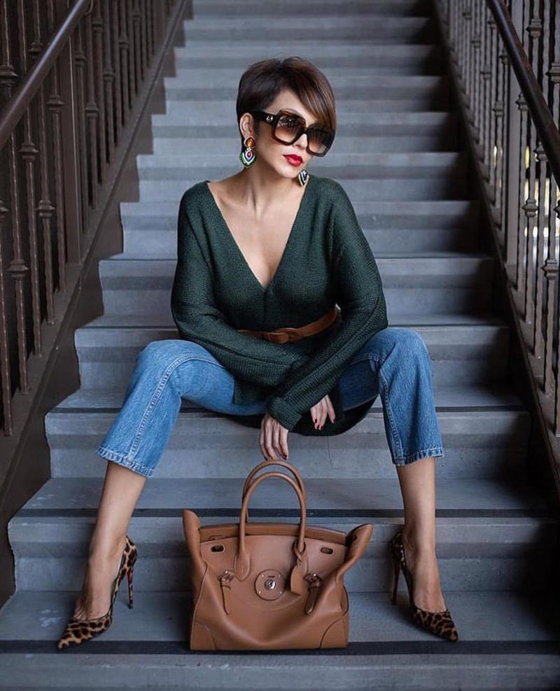 Women's haircut in a short cup 2022 with bangs on the side A woman wearing a green denim blouse and high-heeled shoes