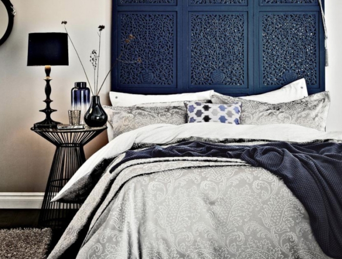 deco tete de lit en bleu foncé mur beige linge de luxe gris et bleu foncé éléments noirs
