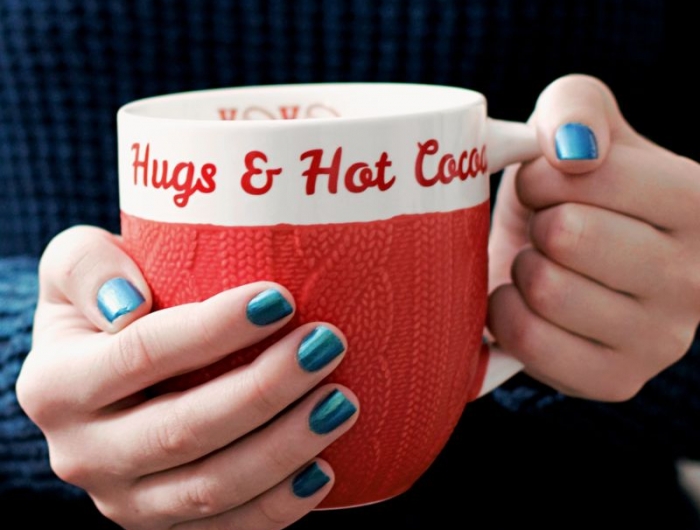idee de manucure une femme qui tient une tasse de chocolat chaud dans ses mains