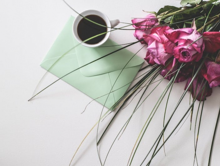 idée de tasse à café flatlay roses enveloppe sur surface blanche