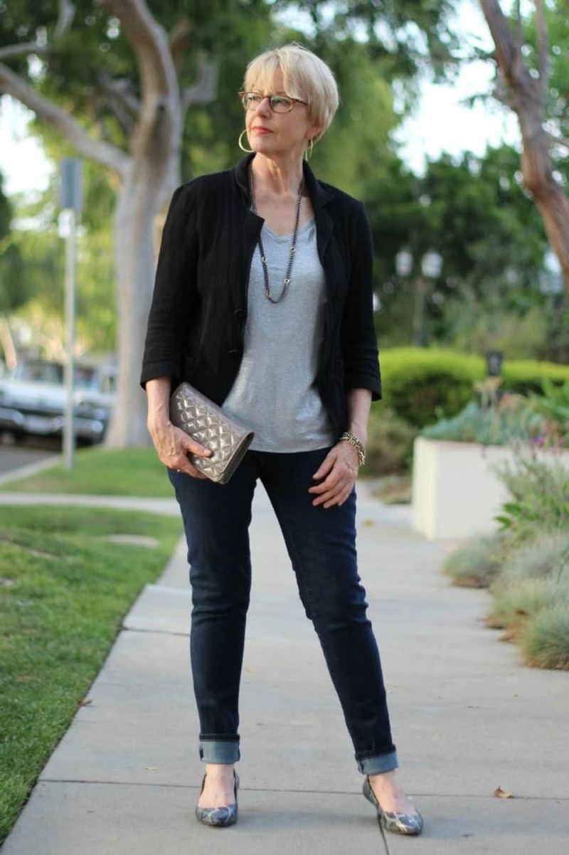 look of a 50 year old woman in dark jeans gray top black jacket gray flat shoes