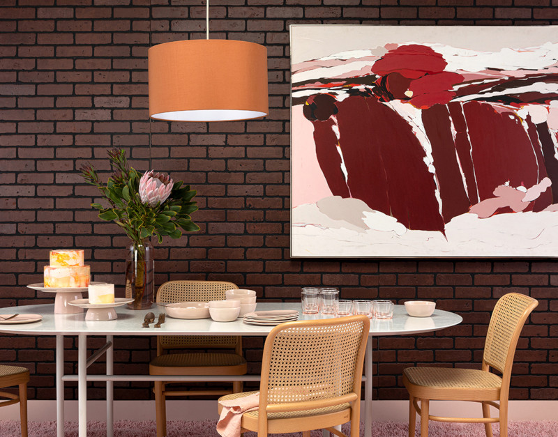 salle à manger tendance 2022 chaises en rotin mur en brique marron plateau de table en marbre