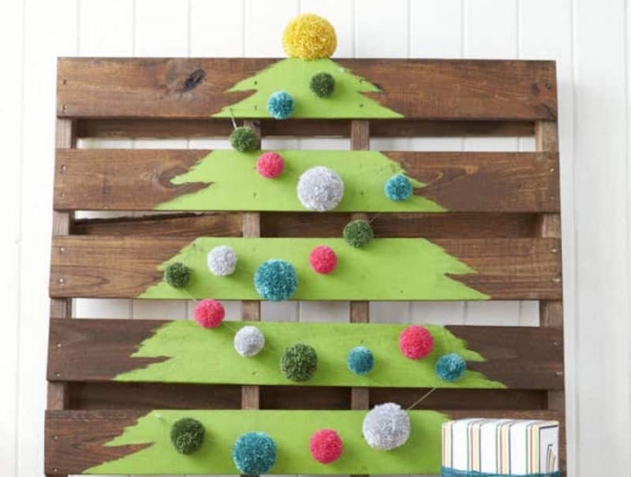 sapin de noel écolo dans une poalette de bois décorée de peinture et de pompons colorés