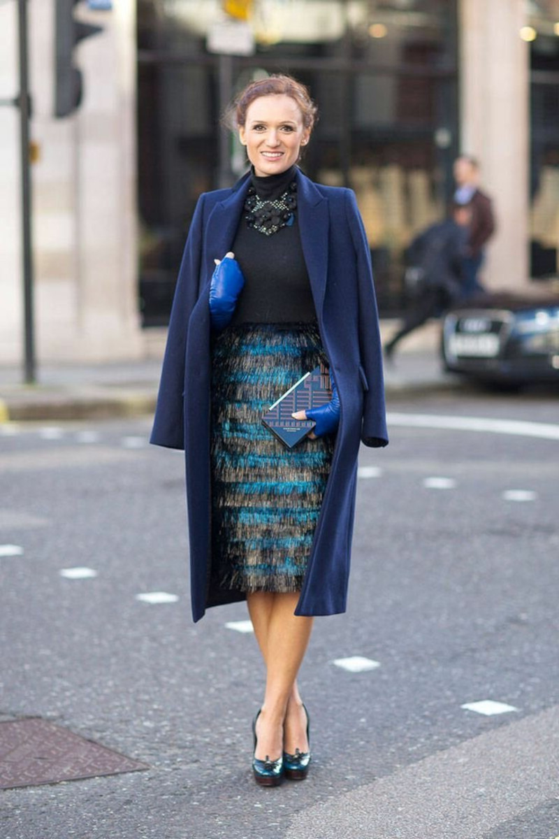 chic style woman with pencil skirt in blue and green coat blue black clutch bag