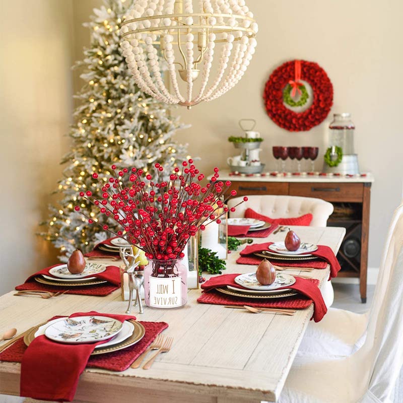 centre de table avec houx en vase et deco serviettes rouges et poires en assiettes