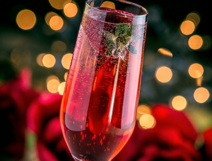 cocktail de noel au champagne et au grenadine avec une fraise flottante