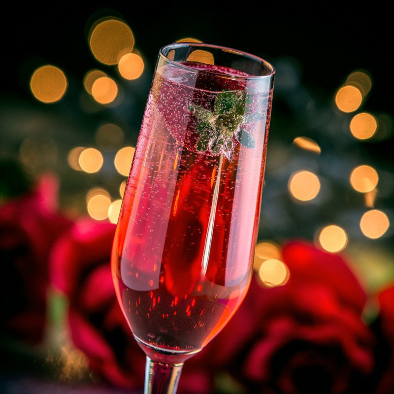 cocktail de noel au champagne et au grenadine avec une fraise flottante
