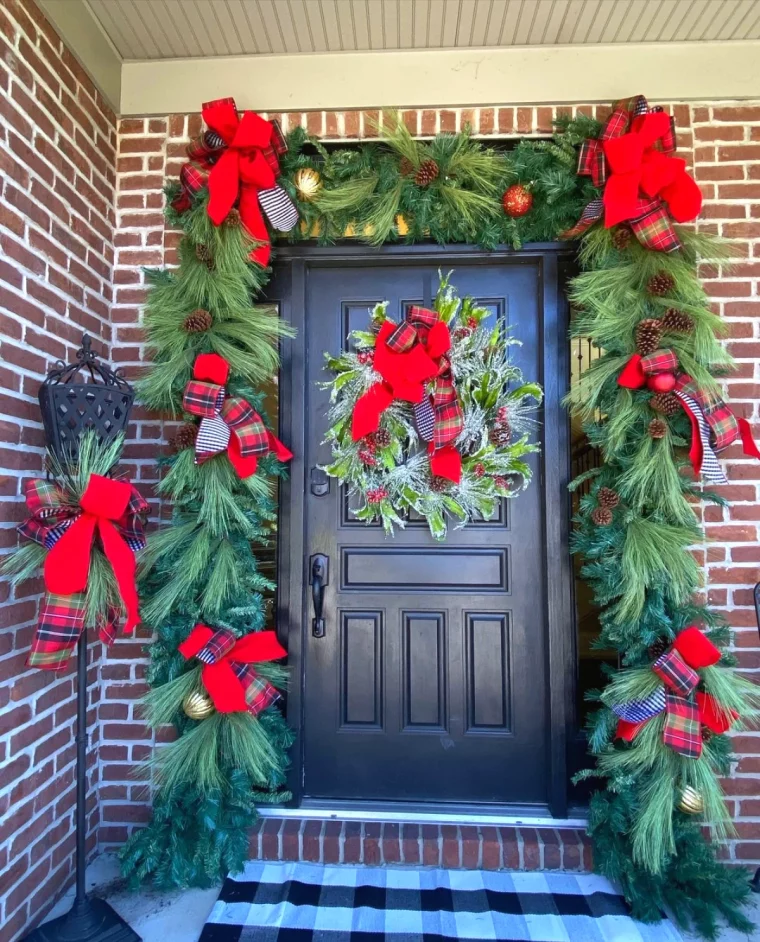 deco de noel au naturel devant la porte avec des noeuds rouges