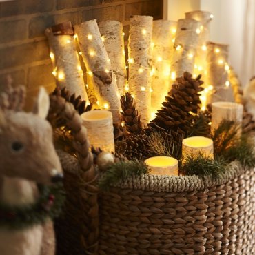 deco noel maison facile panier tressé rempli de bougies led guirlande lumineuse pommes de pin branches bois