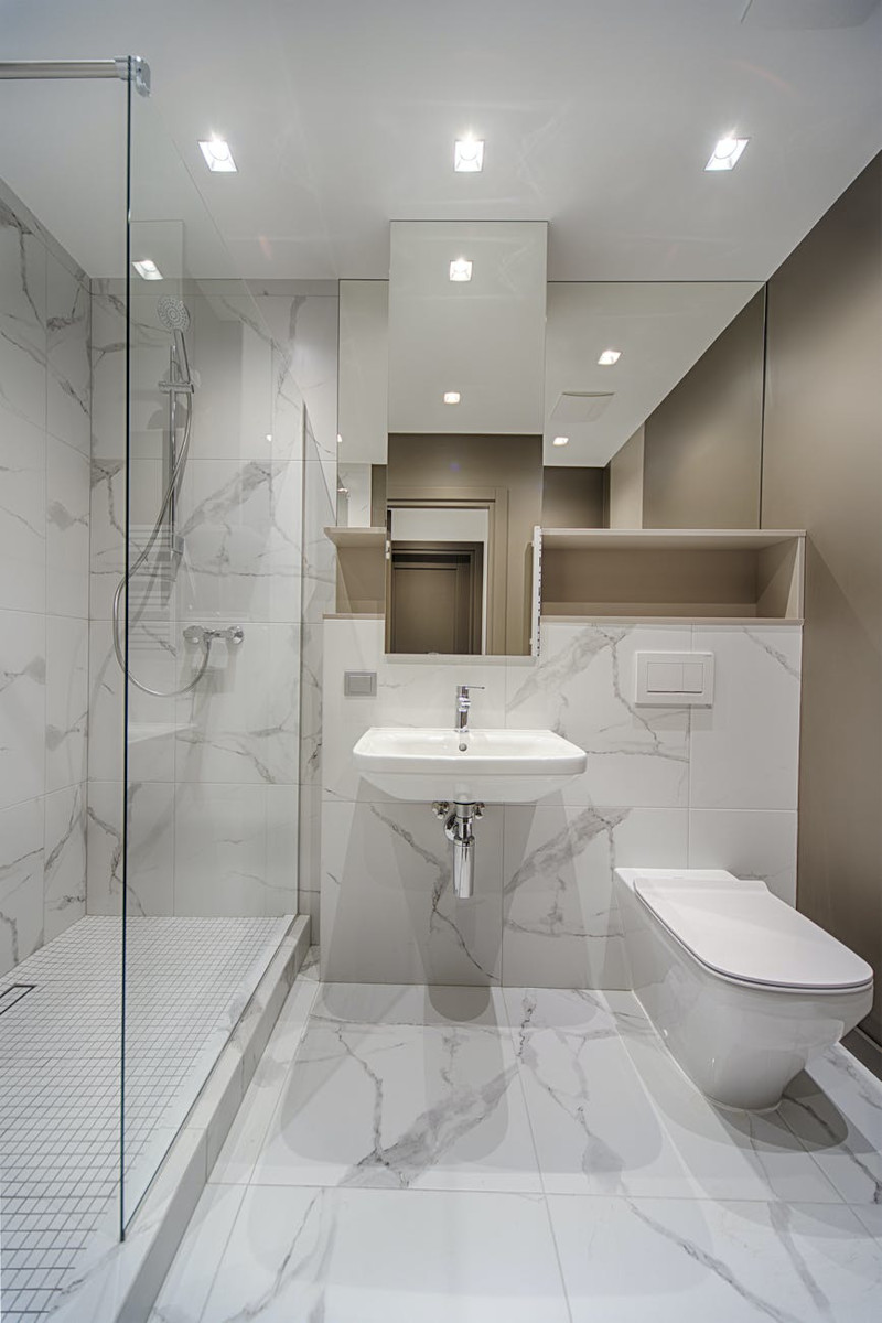 douche italienne avec banc et niche salle de bain en blanc et beige parois en verre