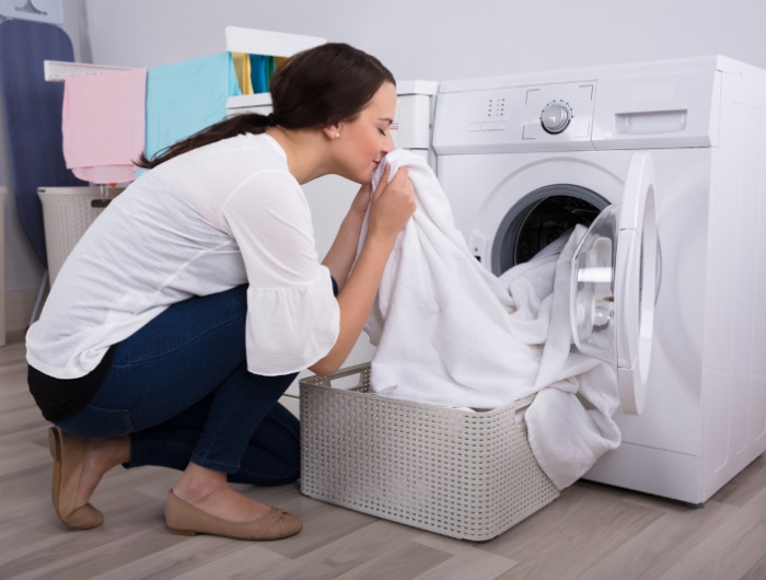 woman smelling cloth after washing in washing machine